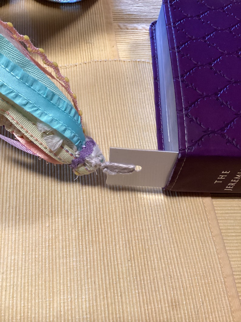 May include: A purple leather-bound book with a silver bookmark attached. The book has a decorative pattern and the text "THE JEREMIAH" is visible on the spine.