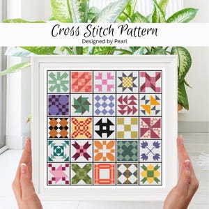Peut inclure: Un motif de point de croix encadré représentant un patchwork avec divers blocs géométriques colorés. Le texte "Cross Stitch Pattern Designed by Pearl" est en haut. L'œuvre est tenue par des mains.