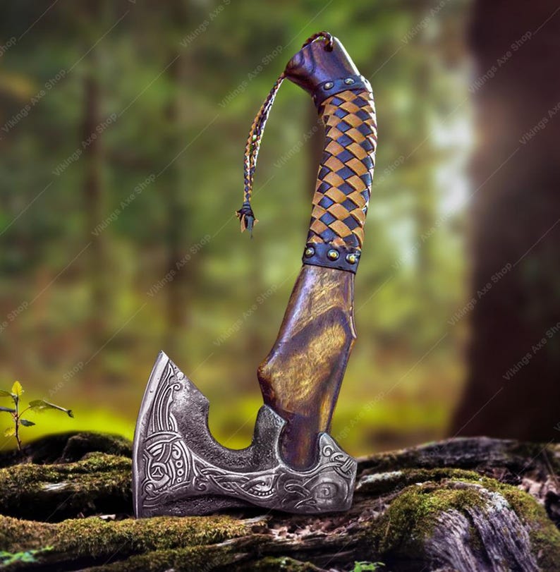 May include: A hand-forged Viking axe with a brown wooden handle wrapped in a braided leather strap. The axe head has intricate carvings and a sharp blade.