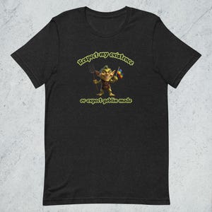 Może przedstawiać: Czarny T-shirt z zielonym goblinem trzymającym widły i tęczową flagę. Tekst "Respect my existence or expect goblin mode" jest nadrukowany na żółto.