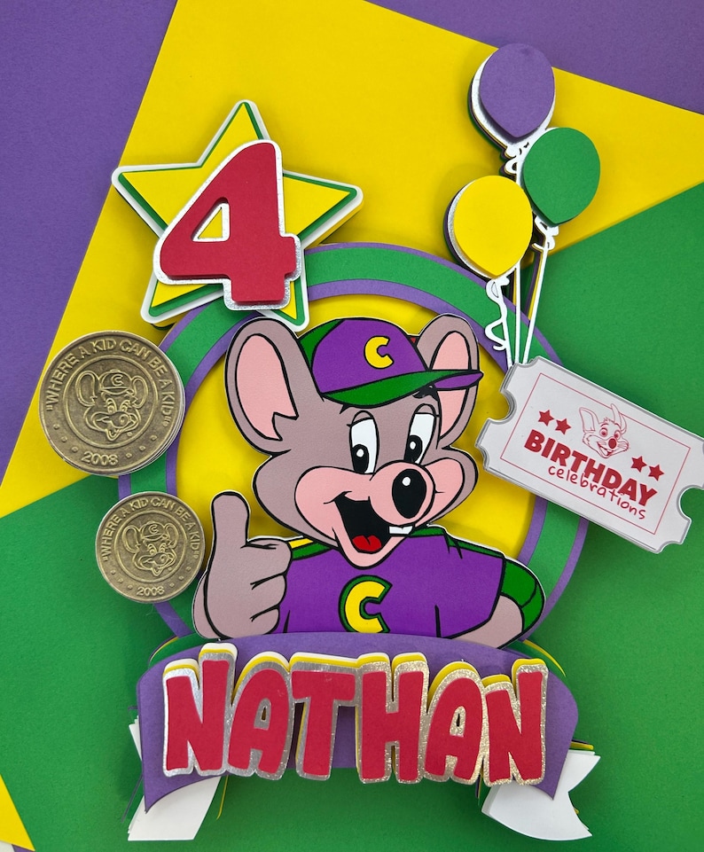Op de afbeelding: Een kleurrijke taarttopper voor een verjaardag met een cartoonmuis, het nummer 4, ballonnen en de naam "Nathan". Inclusief twee munten met de tekst "Where a kid can be a kid" en het jaar 2008. Een ticket leest "Birthday celebrations".