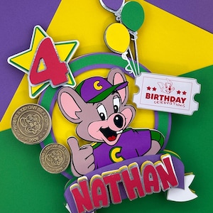 Op de afbeelding: Een kleurrijke verjaardagsdecoratie met een cartoon muis karakter die een duim omhoog geeft. Het ontwerp bevat een ster met het nummer 4, ballonnen, een ticket met de tekst "Birthday Celebrations" en de naam "Nathan".