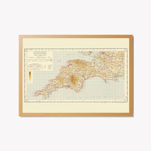 May include: A framed vintage map of the South West Coast of Britain, showing roads and topography. The map is in a wooden frame with a cream mount. The map's title is visible at the top, offering a glimpse into historical cartography.