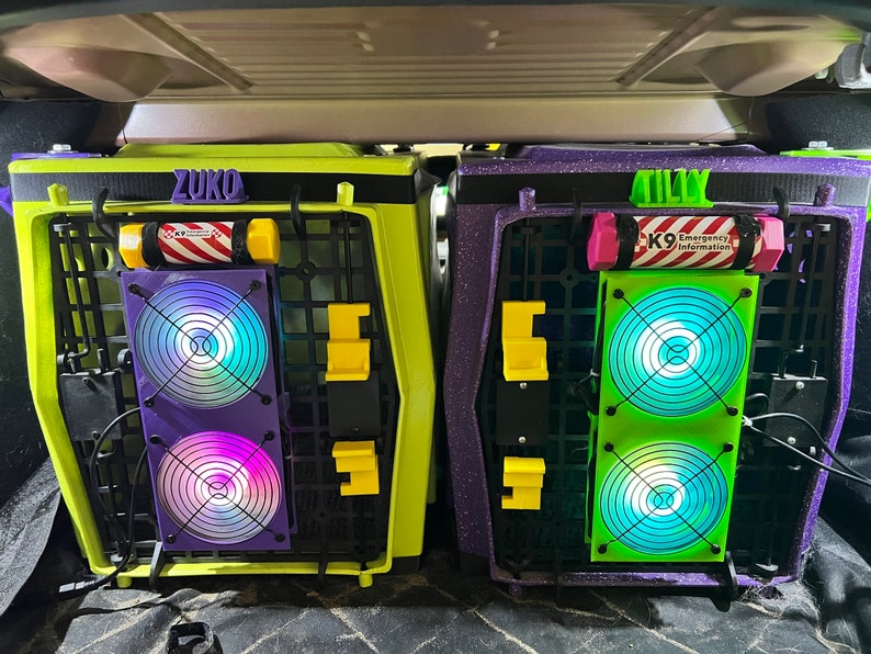 May include: Two green and purple dog crates with the names "Zuko" and "Tilly" on them. Each crate has a fan with a colorful light display.