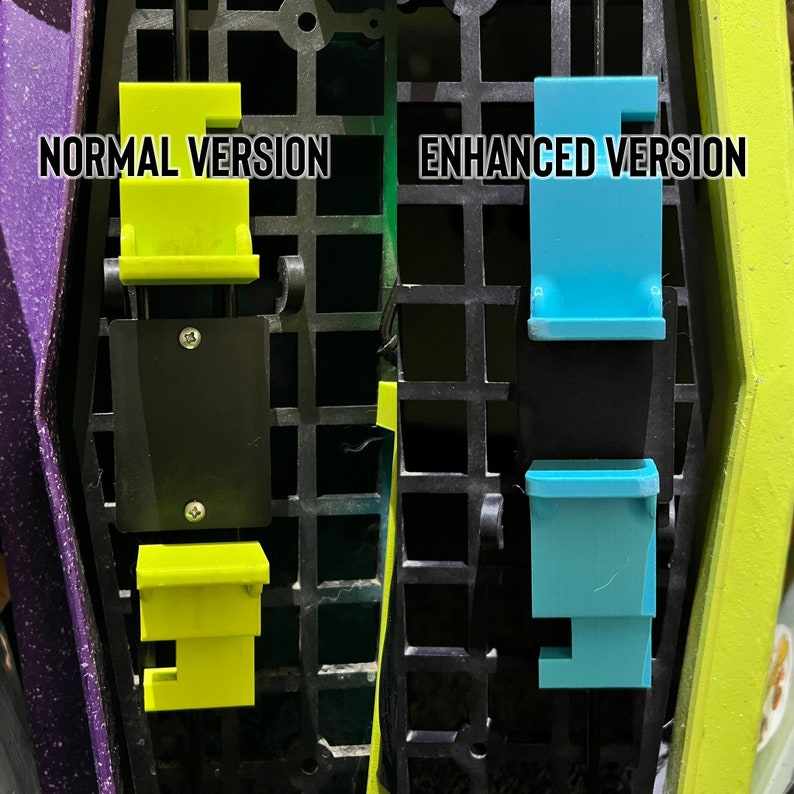May include: Two versions of a phone mount, one in yellow and one in blue. The mount is attached to a black grid. The text "NORMAL VERSION" is above the yellow mount and the text "ENHANCED VERSION" is above the blue mount.