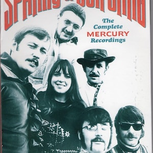 May include: A music album cover titled SPANKY & OUR GANG The Complete MERCURY Recordings. The cover features a black and white photograph of a musical group consisting of six individuals with various hairstyles, glasses, and clothing styles.
