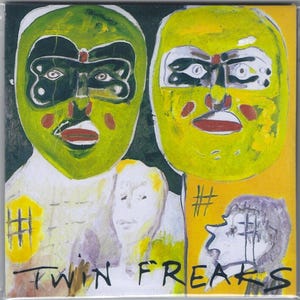 Op de afbeelding: Kunstwerk met twee gemaskerde figuren in groen en geel, met rode accenten en de tekst "TWIN FREAKS". Het kunstwerk heeft een donkere achtergrond met gele en witte elementen. De stijl doet denken aan een stripverhaal of graphic novel.