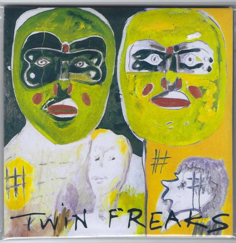 Op de afbeelding: Kunstwerk met twee gemaskerde figuren in groen en geel, met rode accenten en de tekst "TWIN FREAKS". Het kunstwerk heeft een donkere achtergrond met gele en witte elementen. De stijl doet denken aan een stripverhaal of graphic novel.