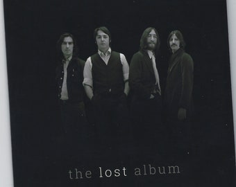 May include: Black and white photo of four men standing in a row. The men are wearing suits and ties. The photo is titled "the lost album".