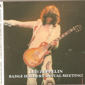 Op de afbeelding: Een cd-hoes met een live concertfoto van Led Zeppelin. De gitarist speelt een sunburst gitaar en draagt een wit pak. De tekst op de hoes luidt "LED ZEPPELIN BADGE HOLDERS ANNUAL MEETING!"