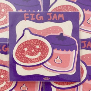 Può includere: Un adesivo quadrato con bordo viola e la scritta "FIG JAM" in rosa. L'adesivo presenta una fetta di fico sorridente e un barattolo di marmellata di fichi in tonalità rosa e viola.