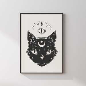 May include: Black and white illustration of a cat's face with a crescent moon and star above its head. A third eye with radiating lines is above the moon.