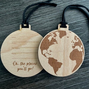 以下が含まれることがあります： 黒い紐で吊るすことができる地球儀の形をした木製オーナメント。オーナメントの裏側には、名前、住所、市、国、電話番号を書くスペースがあります。オーナメントには「Oh, the places you'll go!」というテキストが印刷されています。