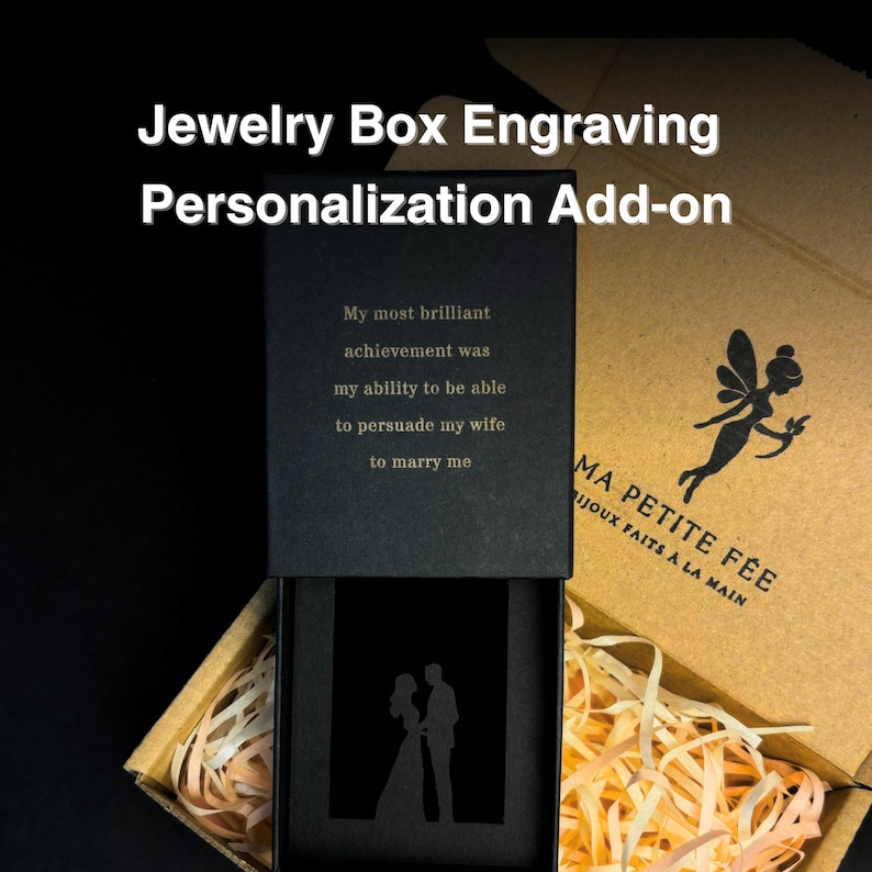 May include: A black jewelry box with a sliding lid featuring the engraved text My most brilliant achievement was my ability to be able to persuade my wife to marry me and a silhouette of a couple. The box sits in a brown cardboard gift box.