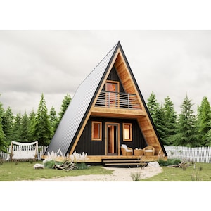 Può includere: Una casa a forma di A in legno e nero con un balcone e una recinzione bianca in legno di fronte. La casa ha un tetto in metallo e grandi finestre. Ci sono due sedie sul portico.