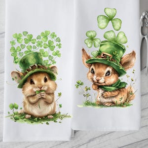 May include: Two white kitchen towels with a green shamrock and a brown leprechaun mouse wearing a green hat and holding a shamrock.
