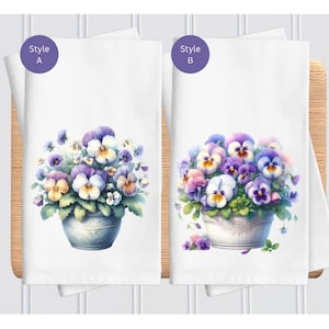 May include: Two kitchen towels with different styles of a floral design. The design features a white pot with purple, pink, and yellow pansies. The text "Style A" and "Style B" are in purple circles on the top left and right corners of the towels.