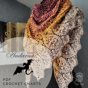 Puede incluir: Un chal de ganchillo hecho a mano en tonos marrón, dorado y burdeos. El chal presenta un intrincado diseño calado y un cierre de botón de madera. El texto "Andarna Shawl" y "PDF Crochet Charts" son visibles.