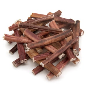 May include: A pile of brown and red bully sticks, a popular dog chew treat.