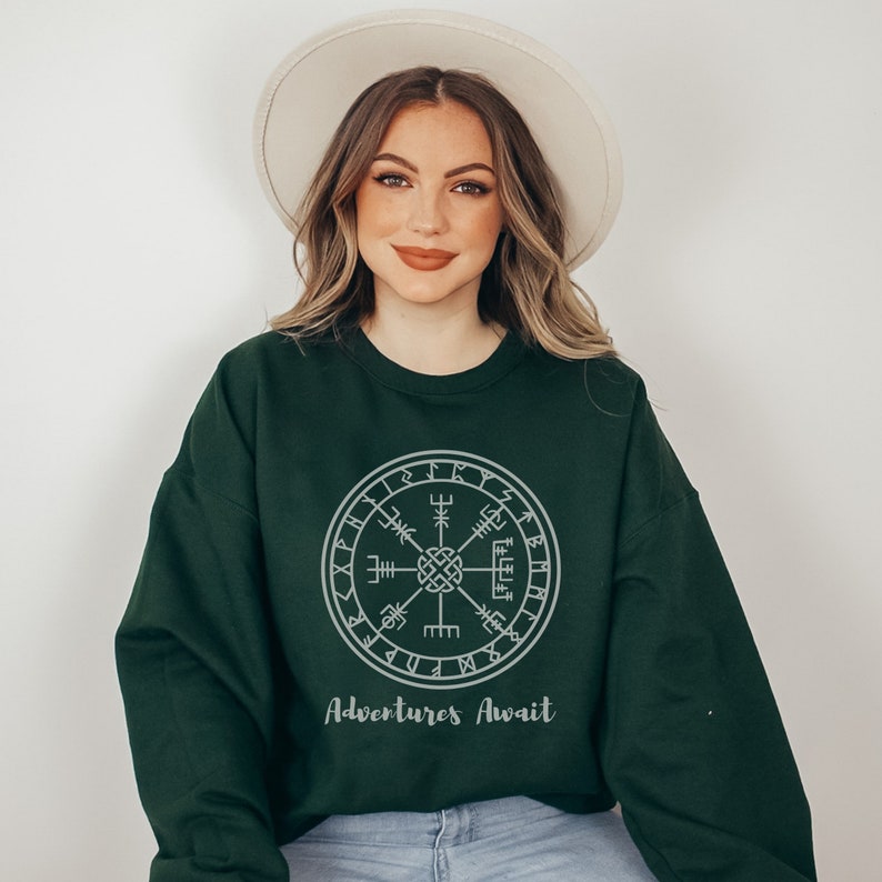 May include: A dark green sweatshirt with a grey compass design and the text "Adventures Await".