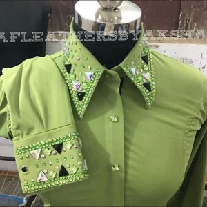 May include: A green button-down shirt with a large embellished collar and cuffs. The collar and cuffs are decorated with rhinestones and black triangular accents.
