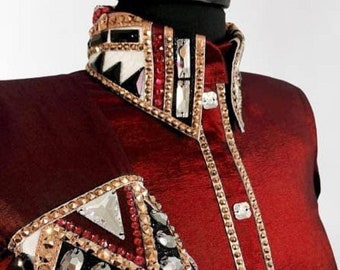 May include: A red, long-sleeved shirt with a decorative collar and a geometric design on the sleeve. The design features rhinestones, gold trim, and black accents. The shirt is labeled "AFCUSTOMBYAKSHAT".