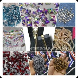 May include: Assortment of craft supplies including iridescent rhinestones, beads, and a gold zipper. The beads are in various colors, including gold, silver, and white.