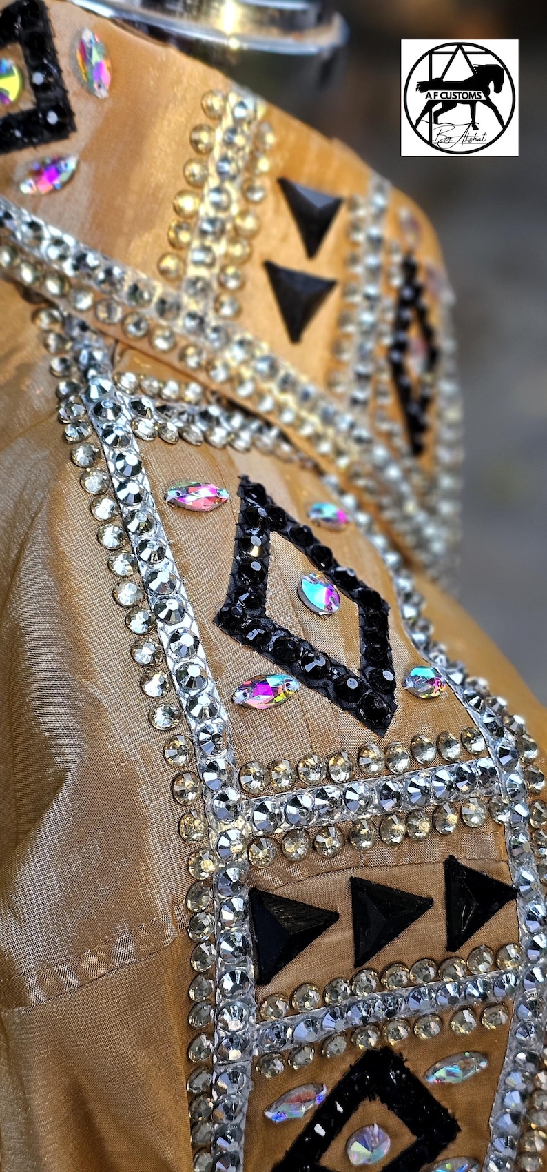 May include: A gold fabric show shirt with black and white geometric designs and rhinestones. The shirt has a black trim and a black and white diamond pattern.