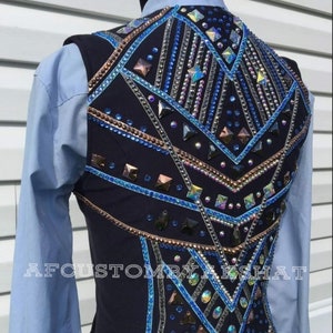May include: A navy blue show vest with a geometric design featuring blue, silver, and copper rhinestones. The vest has a  "AFCUSTOMBYAKSHAT" label on the bottom.