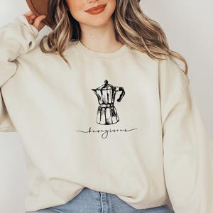 May include: A cream-colored sweatshirt with a black illustration of a coffee pot and the text "Buongiorno" on the front.