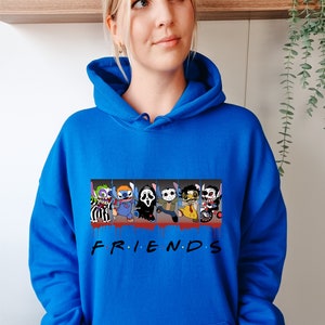 Op de afbeelding: Een koninklijk blauwe hoodie met een grafische print van horrorfilmfiguren in een "Friends"-stijl ontwerp. De personages zijn Stitch, Pennywise, Ghostface, Michael Myers, Freddy Krueger en Jason Voorhees. De tekst "FRIENDS" is onder de personages gedrukt.