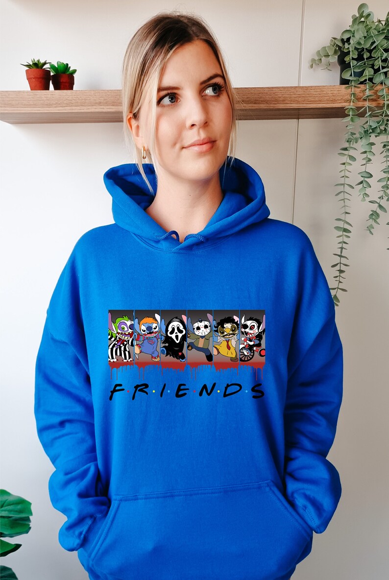 Op de afbeelding: Een koninklijk blauwe hoodie met een grafische print van horrorfilmfiguren in een "Friends"-stijl ontwerp. De personages zijn Stitch, Pennywise, Ghostface, Michael Myers, Freddy Krueger en Jason Voorhees. De tekst "FRIENDS" is onder de personages gedrukt.