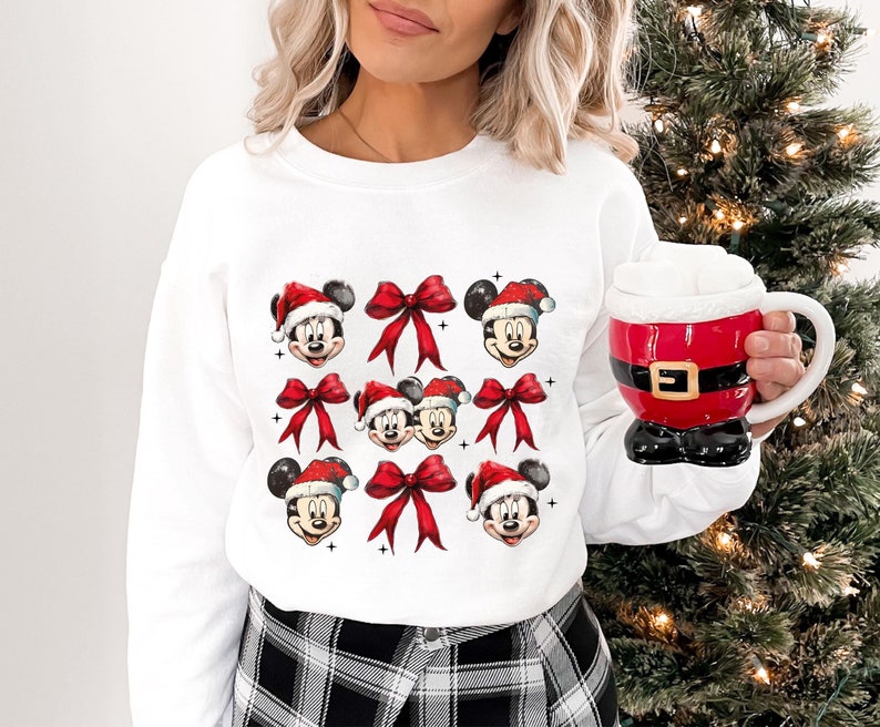 a woman holding a coffee mug in front of a christmas tree