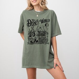 a woman wearing a disney world t - shirt