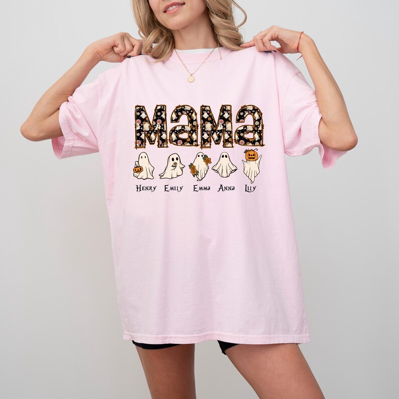 May include: Pink t-shirt with the word "Mama" in black and white with a floral pattern.  Five ghosts are lined up below the word "Mama" with the names Henry, Emily, Emma, Anna, and Lily written below each ghost.