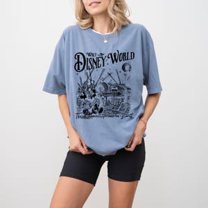 a woman wearing a disney world t - shirt