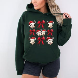 a woman wearing a mickey mouse christmas sweatshirt