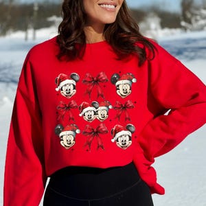 a woman wearing a mickey mouse christmas sweater