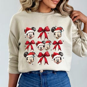 a woman wearing a sweater with mickey mouses on it