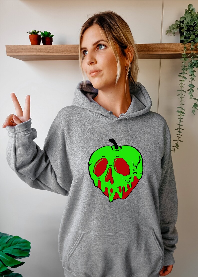 Op de afbeelding: Grijs hoodie met een groene appel print. De appel heeft een schedel gezicht met rode ogen en een druipend groen en rood ontwerp.