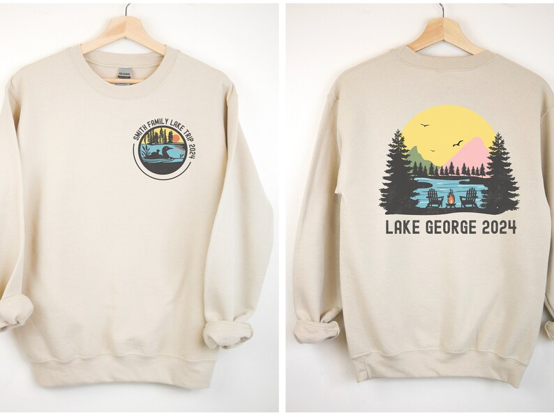 Puede incluir: Una sudadera beige con un gr&aacute;fico circular en la parte delantera que dice "Smith Family Lake Trip 2024" y un gr&aacute;fico de una escena de lago con una fogata en la parte posterior que dice "Lake George 2024".