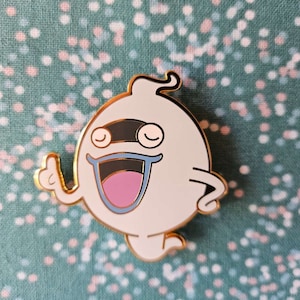 May include: A white ghost with a black eye patch and a big smile, wearing a gold outline. The ghost is giving a thumbs up.