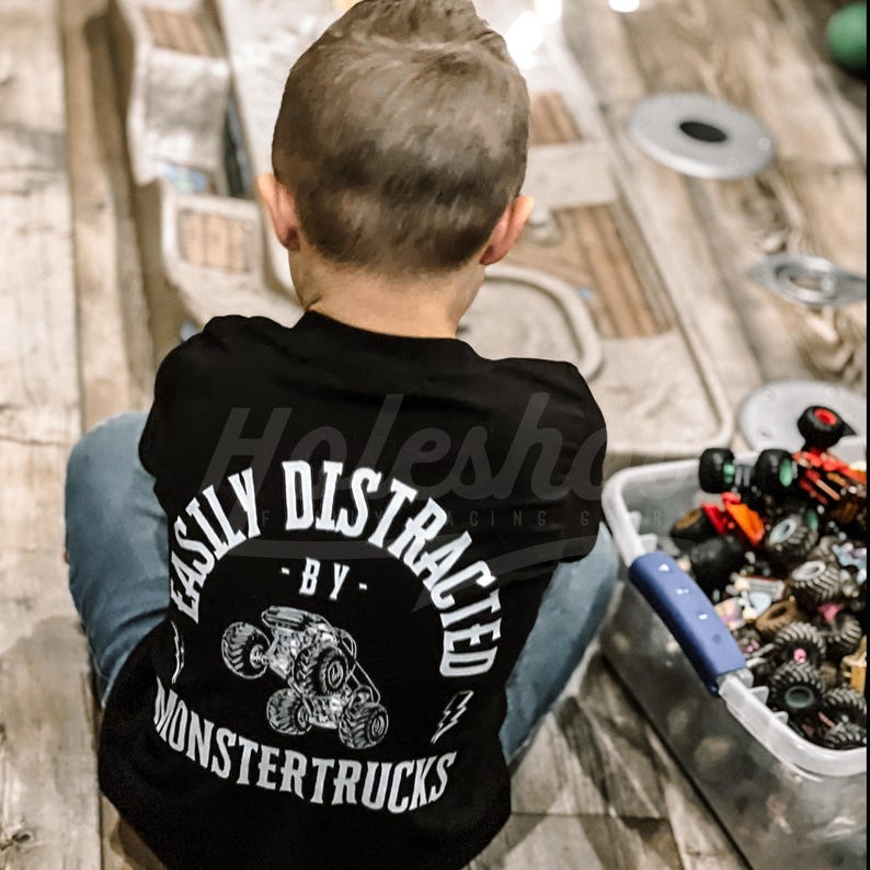 May include: A black t-shirt with a white graphic that says "Easily Distracted - By Monster Trucks".