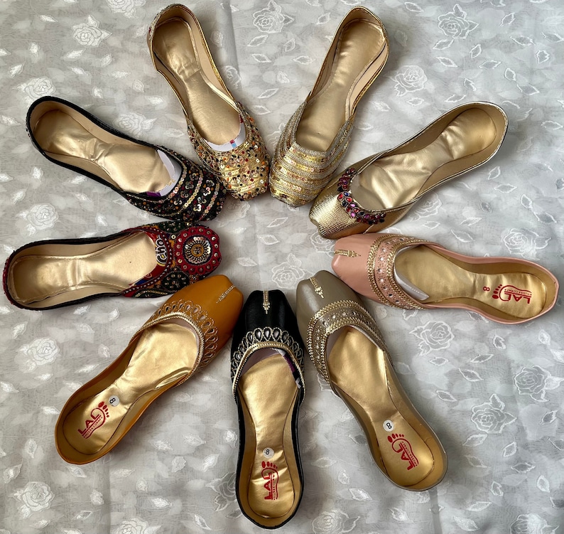 May include: Ten pairs of gold, silver, and black embroidered shoes with jeweled embellishments. The shoes have pointed toes and are decorated with intricate patterns.
