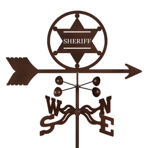 May include: A brown metal weather vane with a sheriff's star design. The star has the word "SHERIFF" inscribed inside. The vane has four directional arrows pointing north, south, east, and west.
