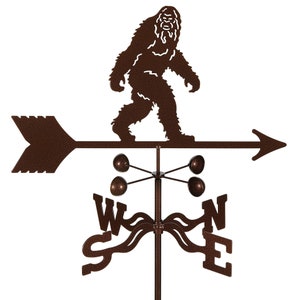 May include: A brown metal weather vane featuring a silhouette of Bigfoot walking to the right. The vane has a compass rose with the letters N, S, E, and W. The vane is mounted on a metal pole.