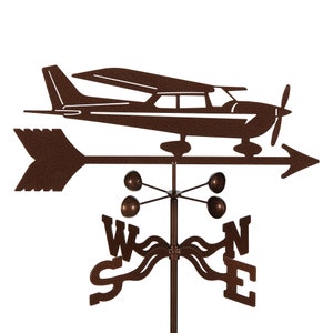 May include: A brown metal airplane weather vane with a compass rose and four ball finials. The airplane is facing right and the compass rose is pointing north.