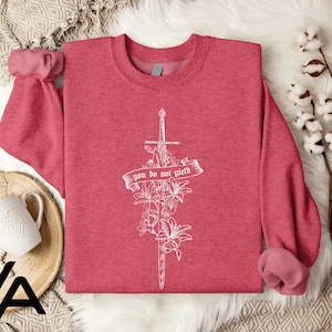 a pink shirt with a cross and flowers on it