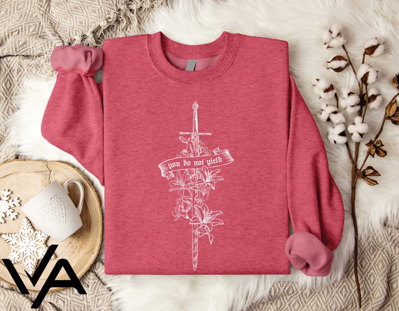a pink shirt with a cross and flowers on it