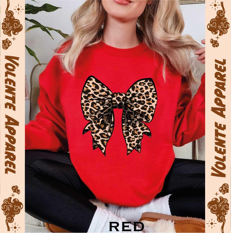 a woman wearing a red sweater with a leopard print bow
